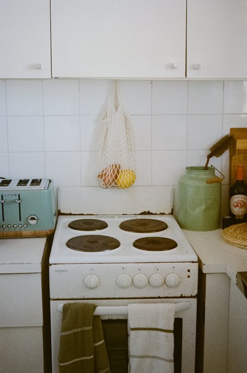 Interior of cozy kitchen with aged cooking stove and cupboard in bright daylight