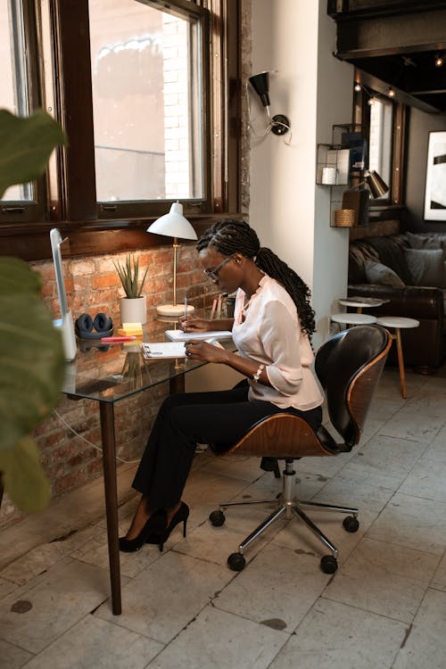 Woman Writing On Notepad At Work