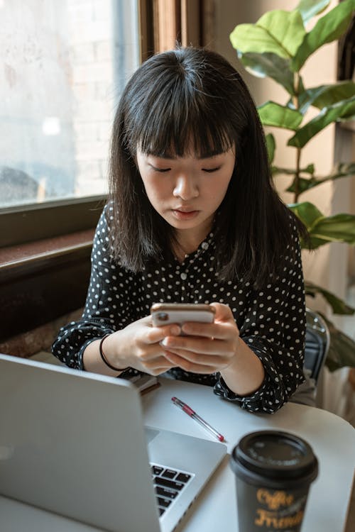 Vrouw In Zwart Wit Polkadot Shirt Met Lange Mouwen Met Zilveren Iphone 6