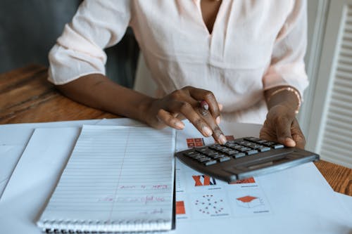 Free Person in White Dress Shirt Using A Calculator Stock Photo