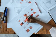 Person Holding Marker and Writing on Paper