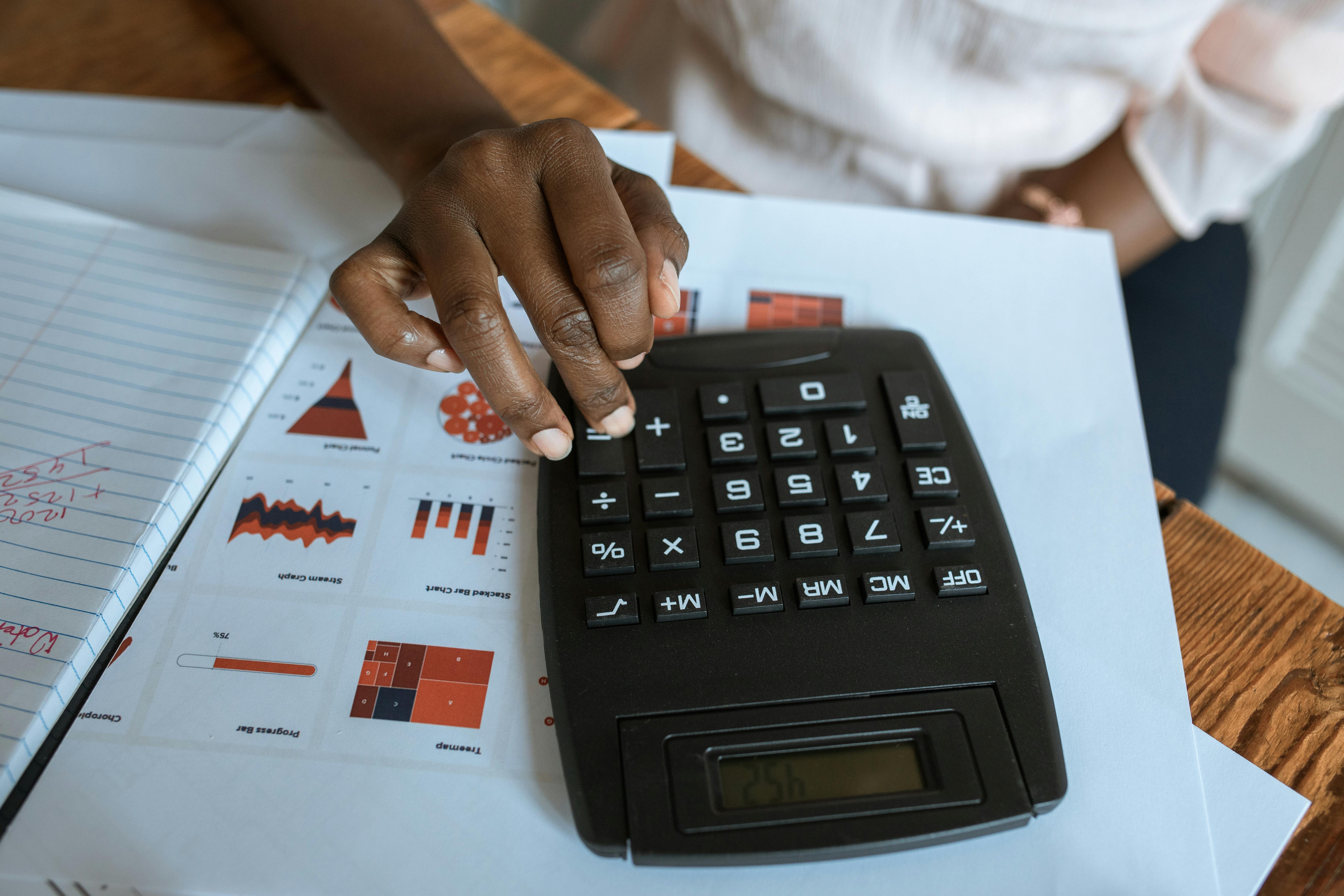 person using black desk calculator