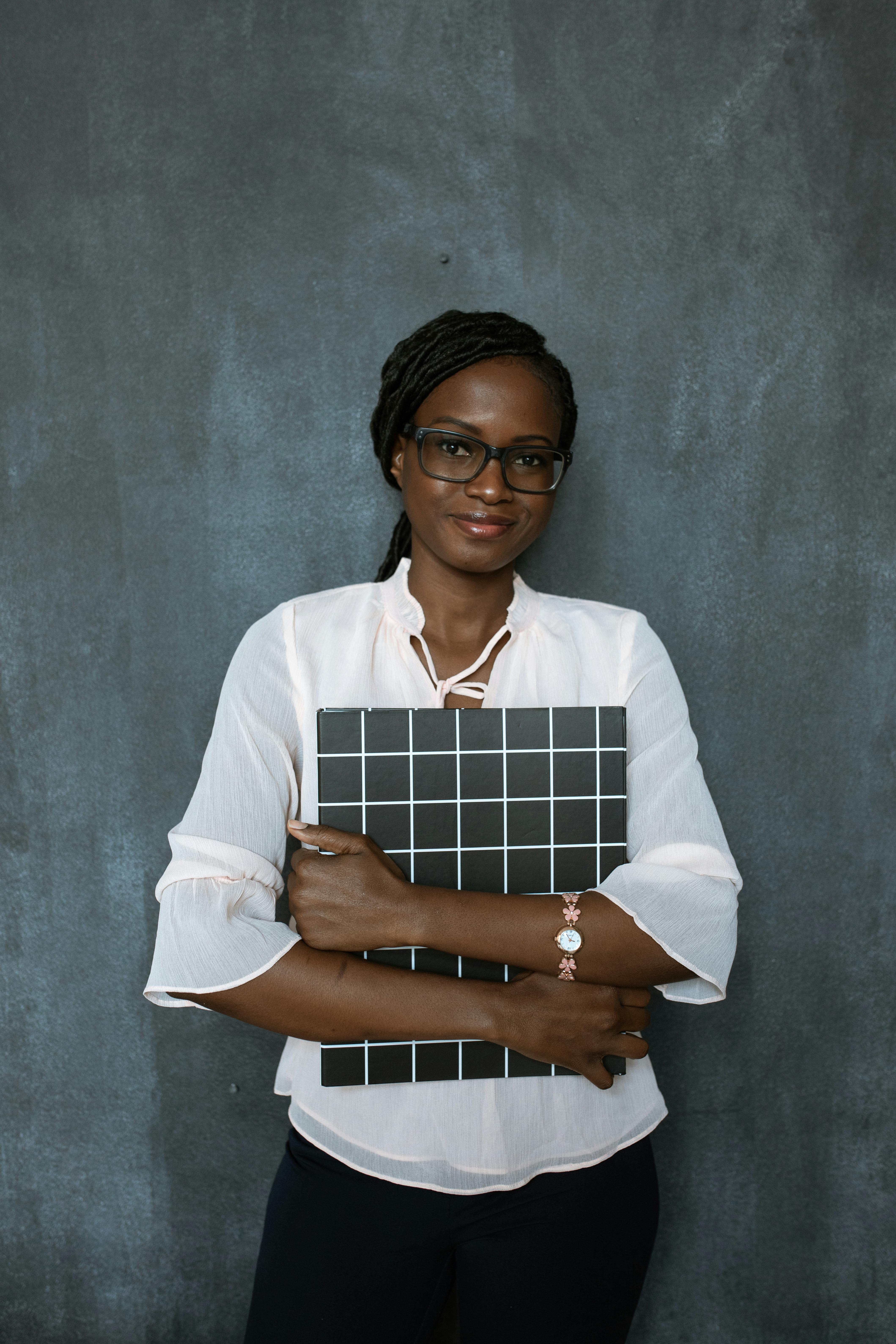 woman in white dress shirt holding brown and white paper