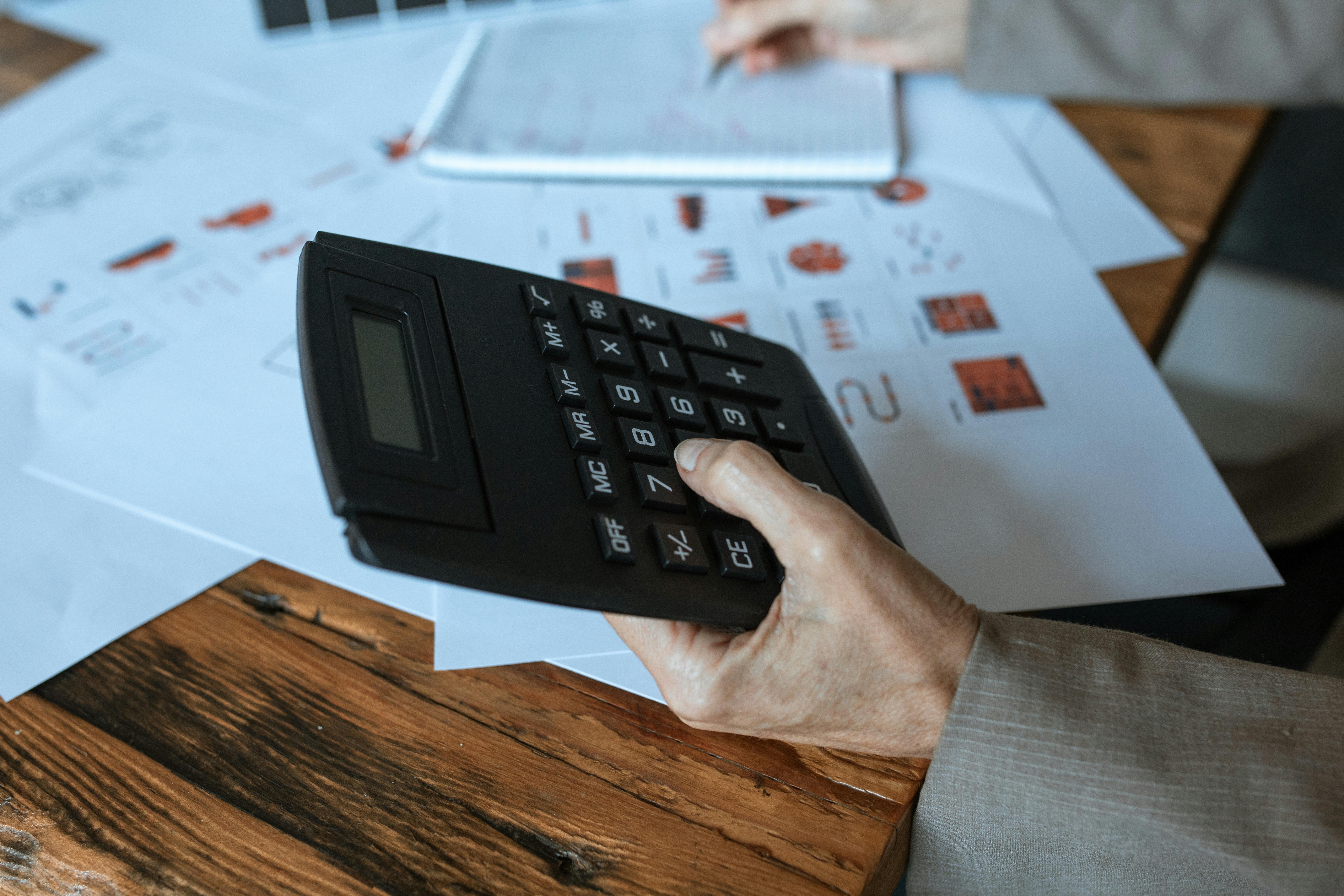 person holding black desk calculator