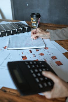 An office desk scene featuring charts, calculator, and coffee cup, ideal for business or finance themes.
