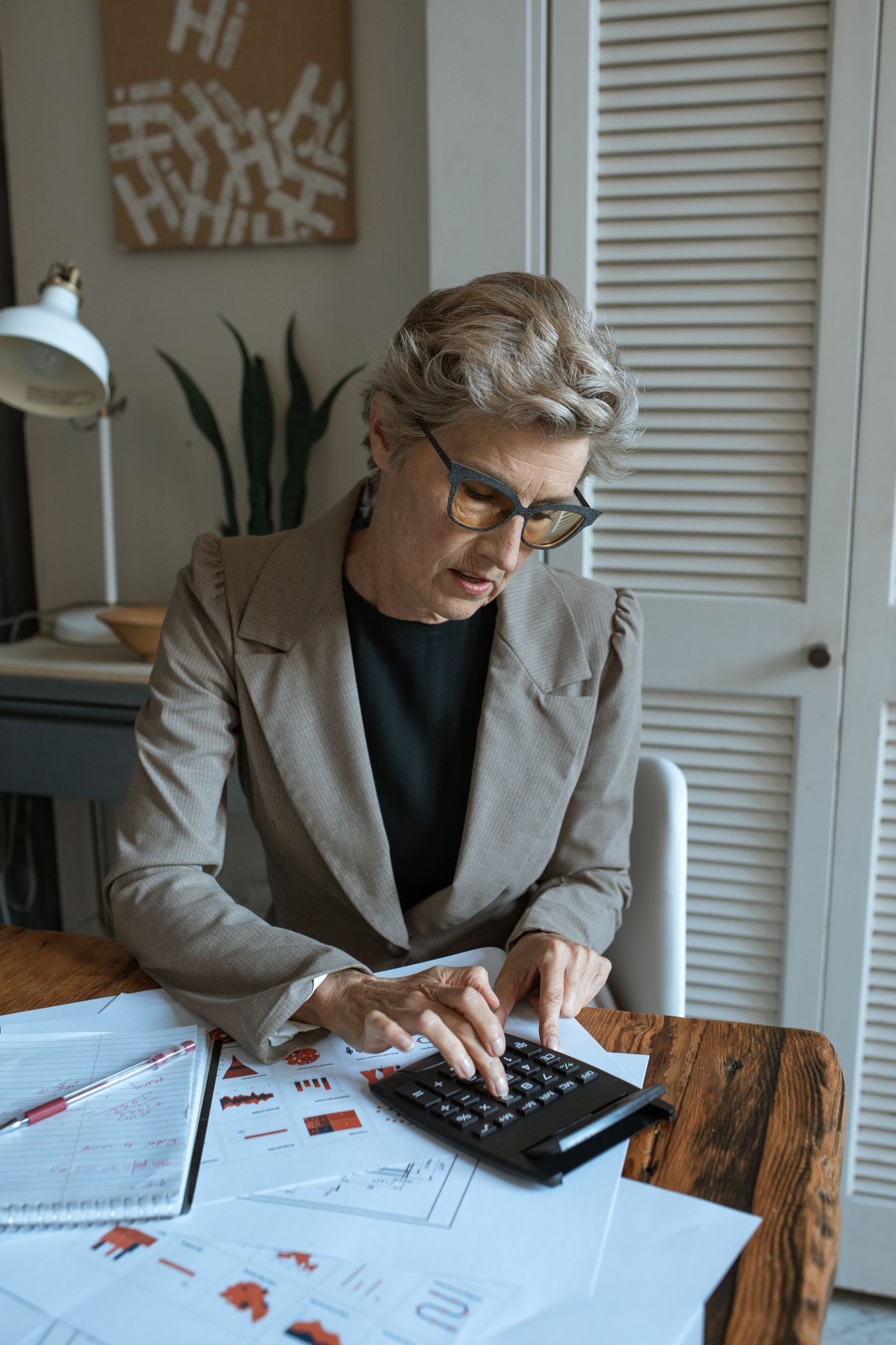 Professional using laptop and calculator for bookkeeping