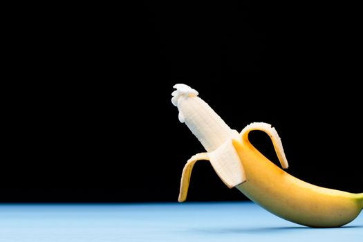 A vibrant close-up of a peeled banana against a contrasting blue surface, showcasing its freshness and appeal.