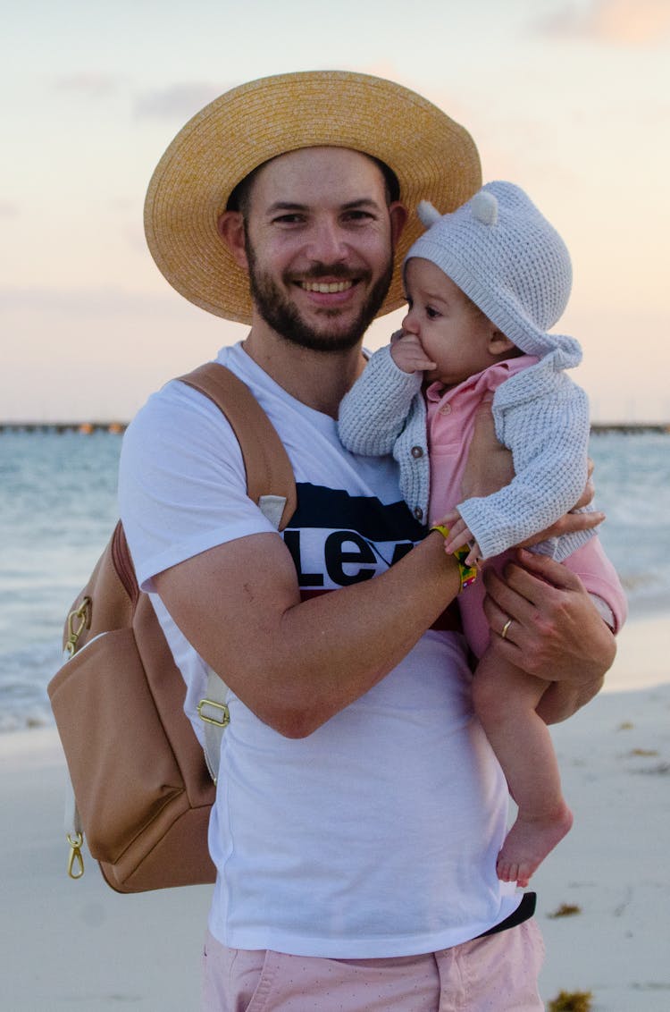 Man In White Shirt Carrying A Baby