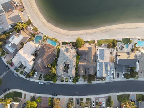 Aerial shot of residential homes along the beach in Huntington Beach, CA, capturing rooftops and coastal scenery.