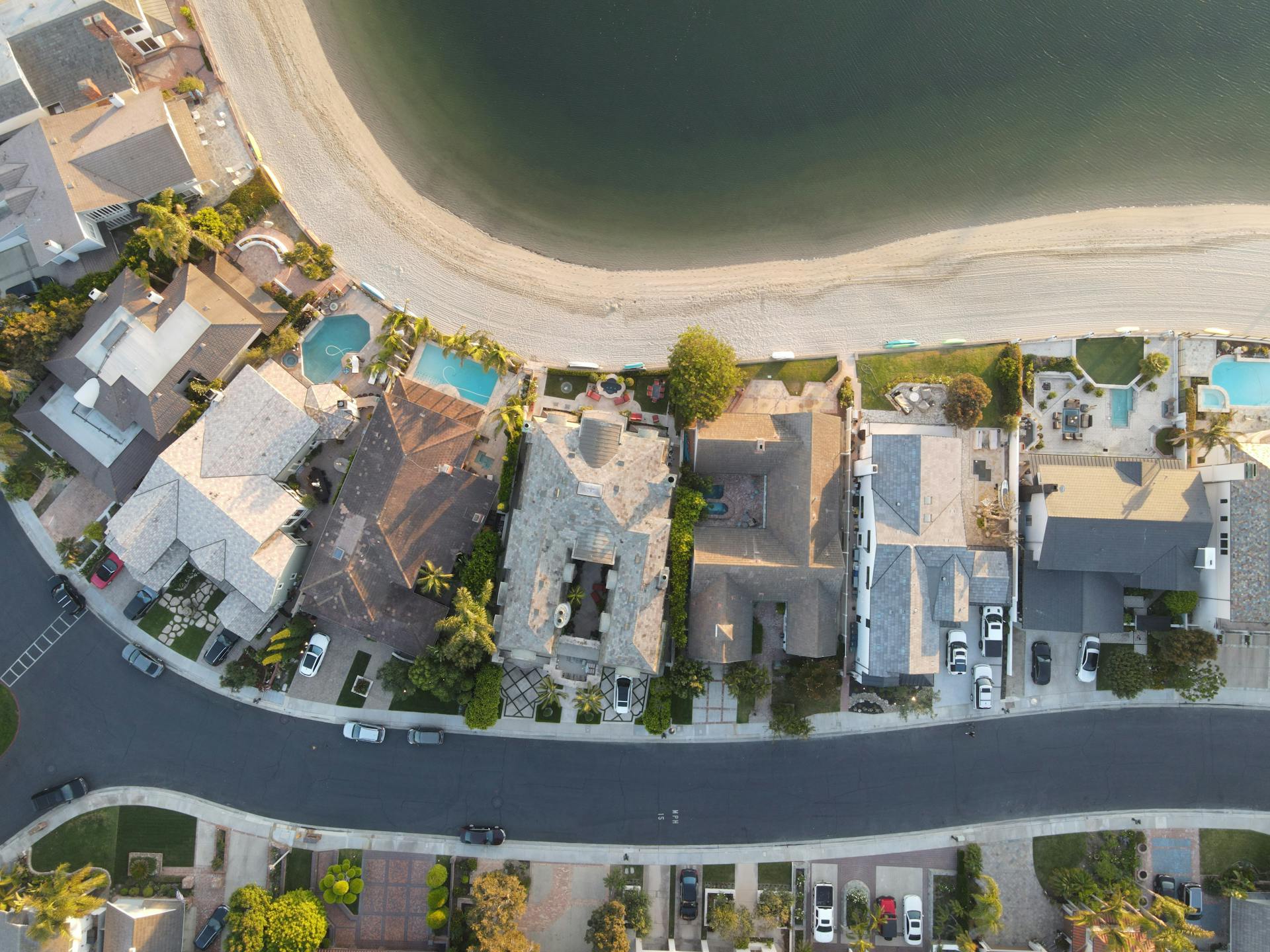 Aerial shot of residential homes along the beach in Huntington Beach, CA, capturing rooftops and coastal scenery.