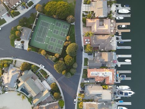 Aerial drone shot showing a marina in Huntington Beach with tennis courts and nearby houses.