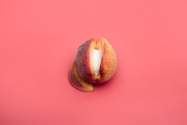 Sliced Peach Fruit On Light Pink Background