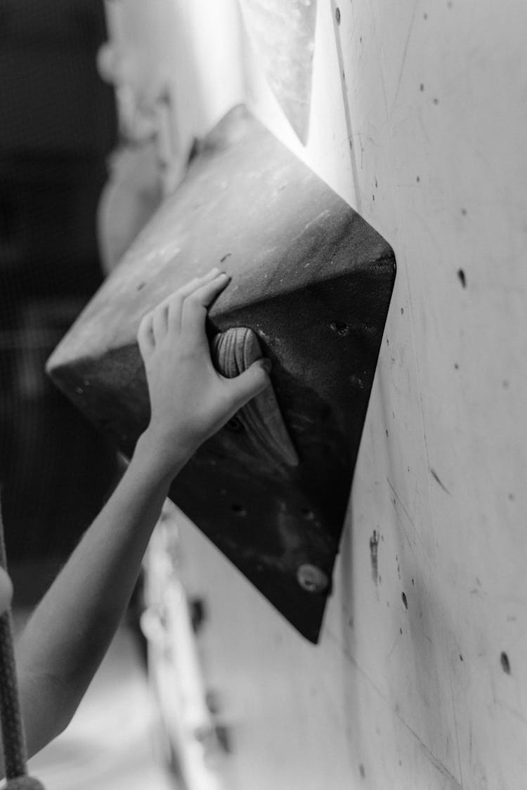 Grayscale Photo Of A Hand Holding On A Grip