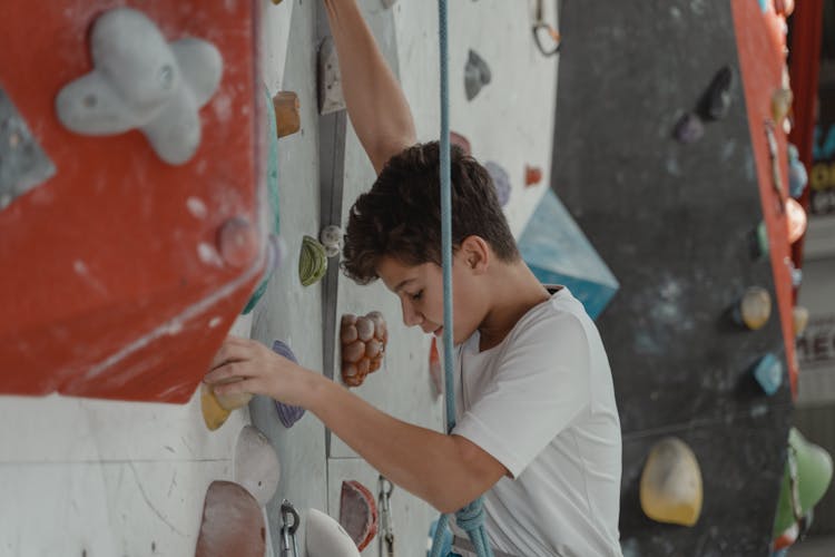 A Boy Holding On Grips Looking Down