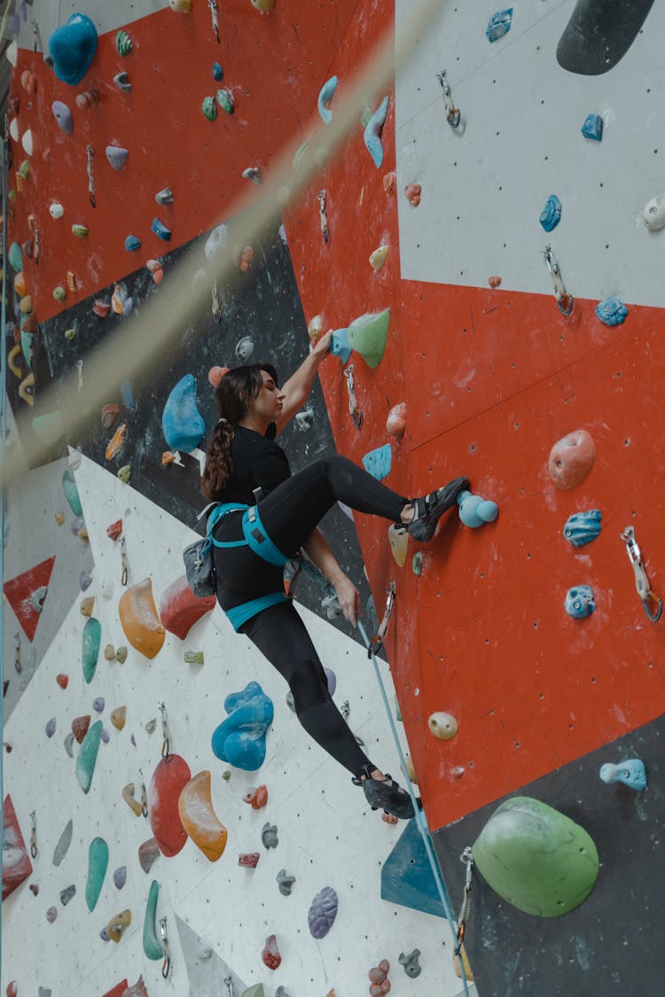 A Woman Climbing A Wall