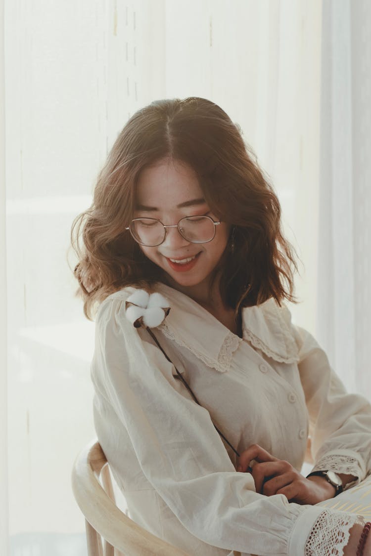 A Pretty Woman Wearing A Dress Holding A Cotton Flower