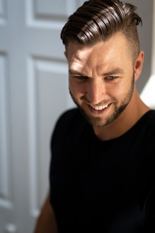 Free Close-up of a smiling man in sunlight inside a Vancouver home. Stock Photo