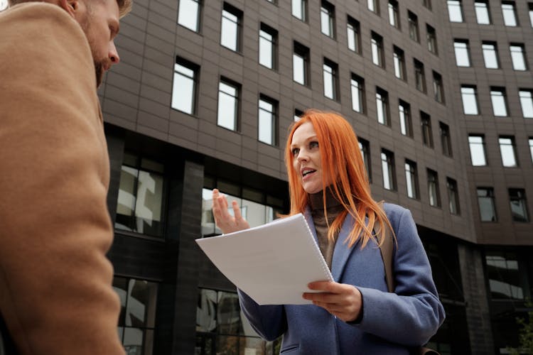 Woman In Blue Coat Holding A Document