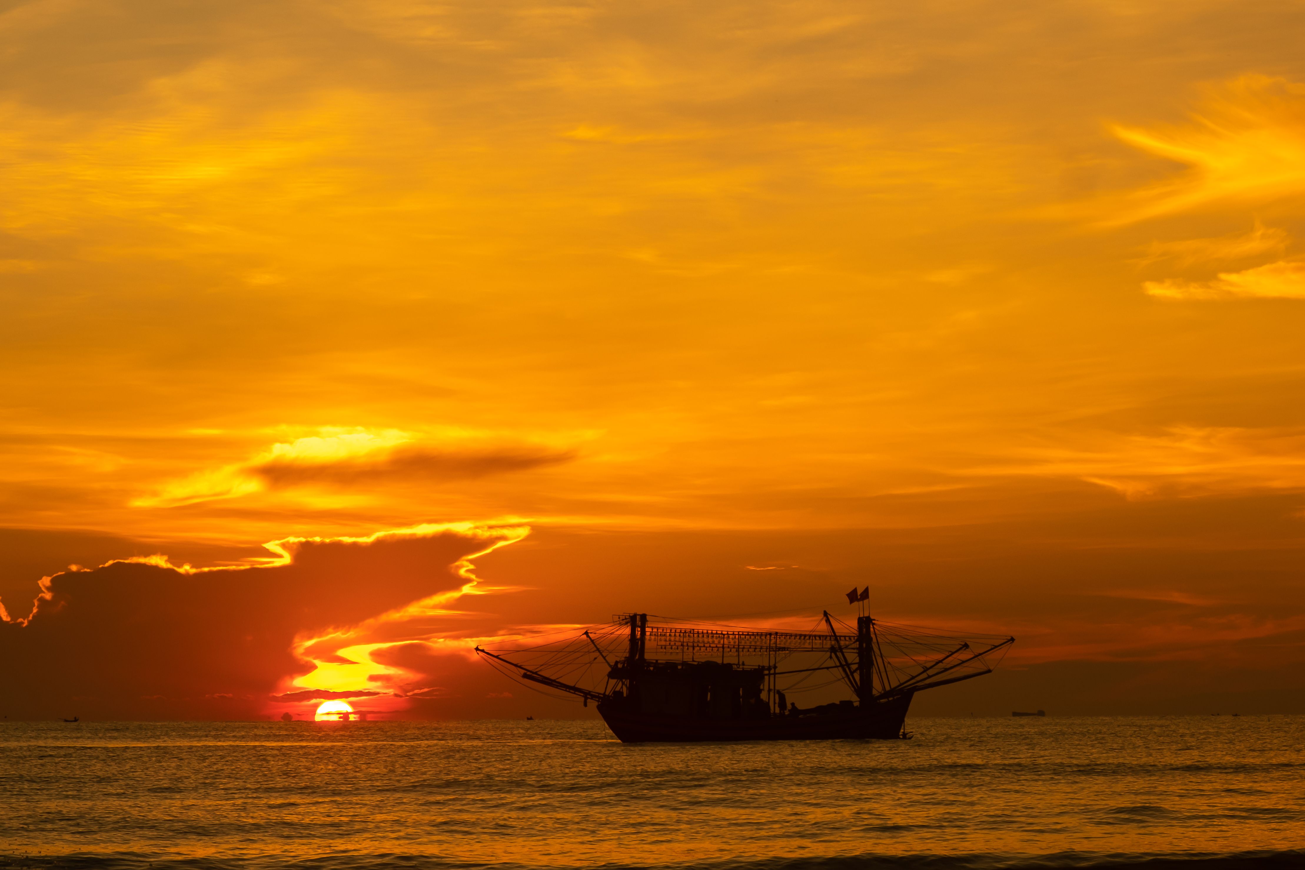 Silhouette of a Ship on Sea during Sunset · Free Stock Photo