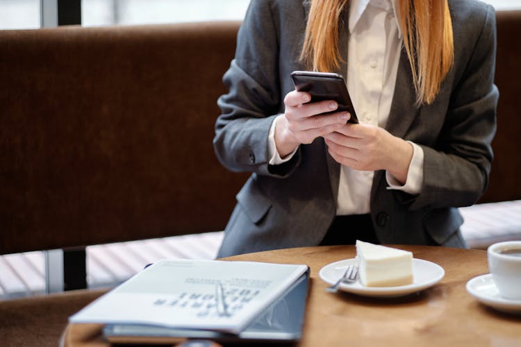 Woman In Gray Blazer Texting On A Smartphone