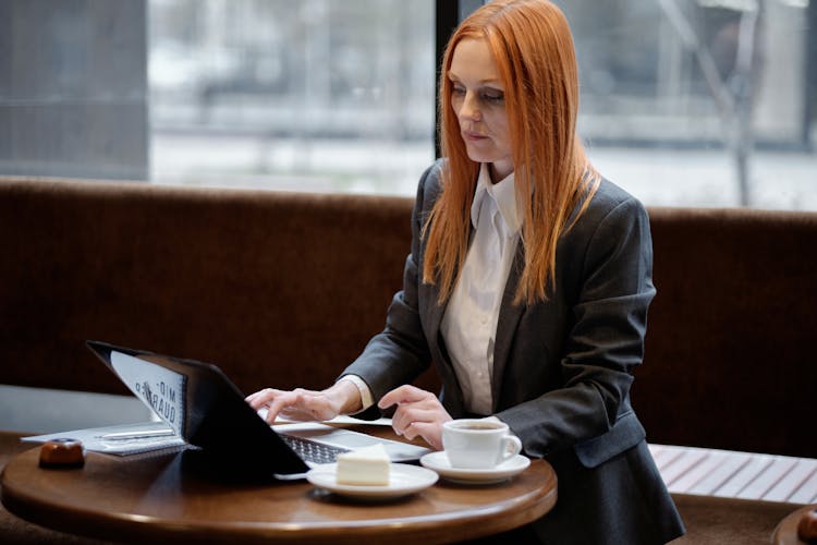 Woman In Blazer Using A Laptop