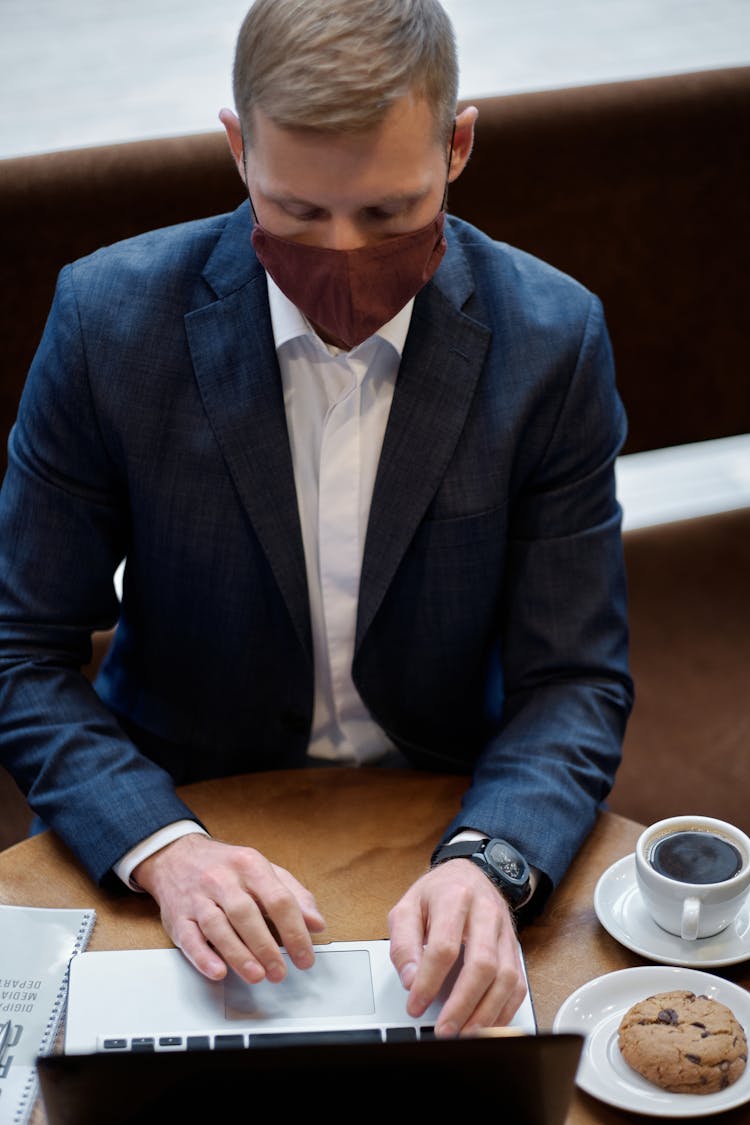 Man In Business Attire Working In A Coffee Shop