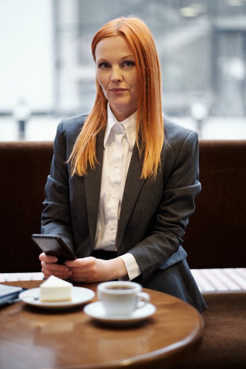 Woman in Black Blazer Sitting on Brown Chair