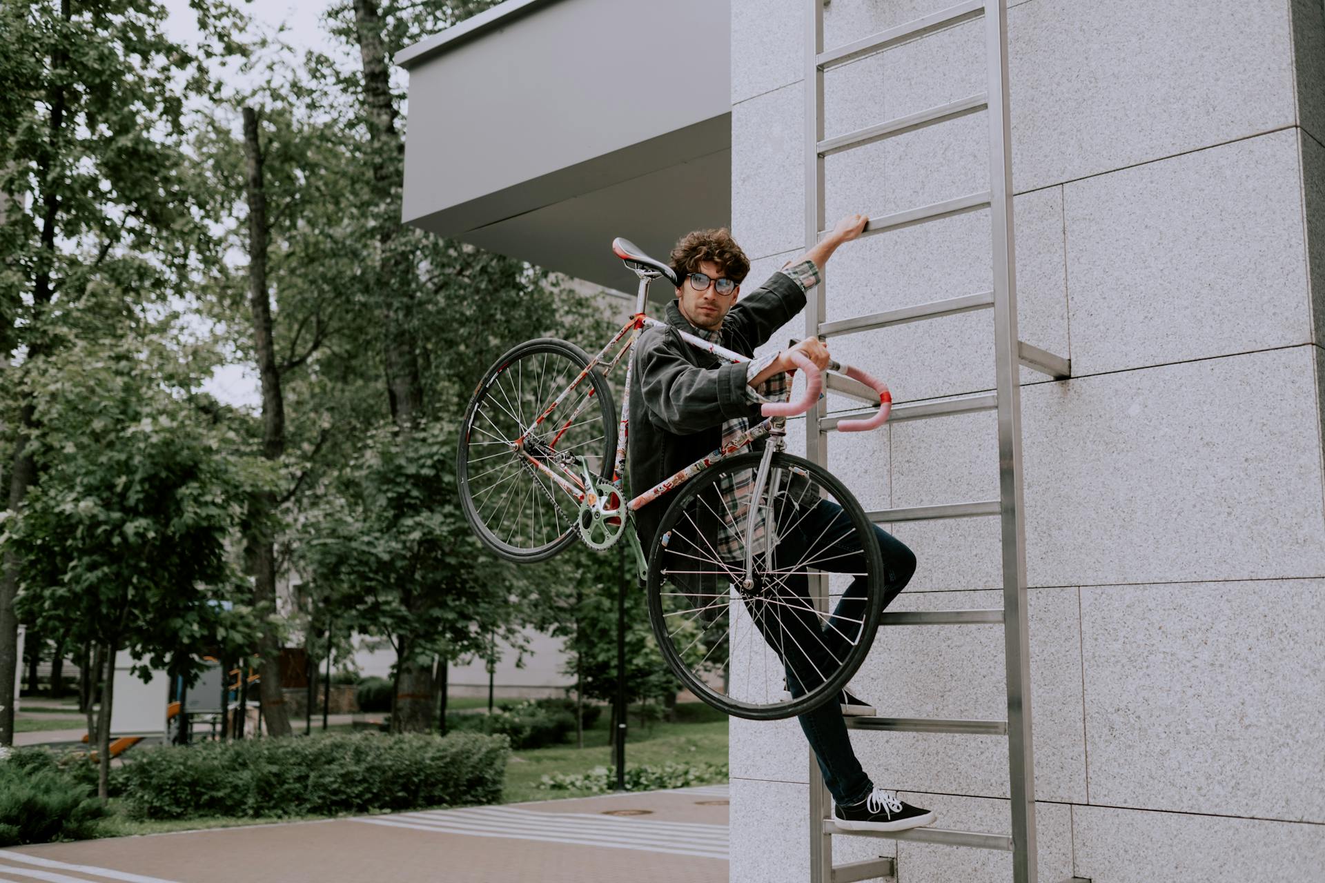 Man Climbing Up Ladder with Bike on Shoulder