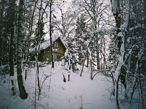 Free From below of old shabby house with roof covered with snow in daytime in winter Stock Photo