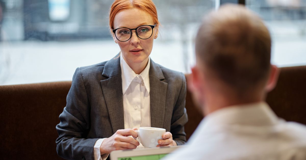Person sitting at desk with laptop and notebook, preparing for an interview