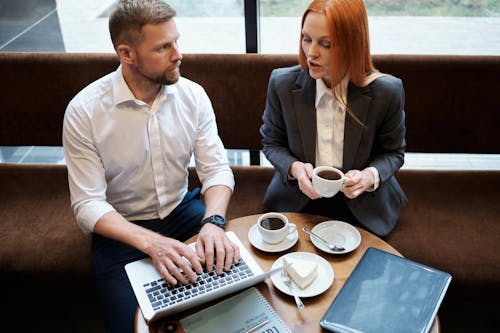Man and Woman Having Coffee While Working