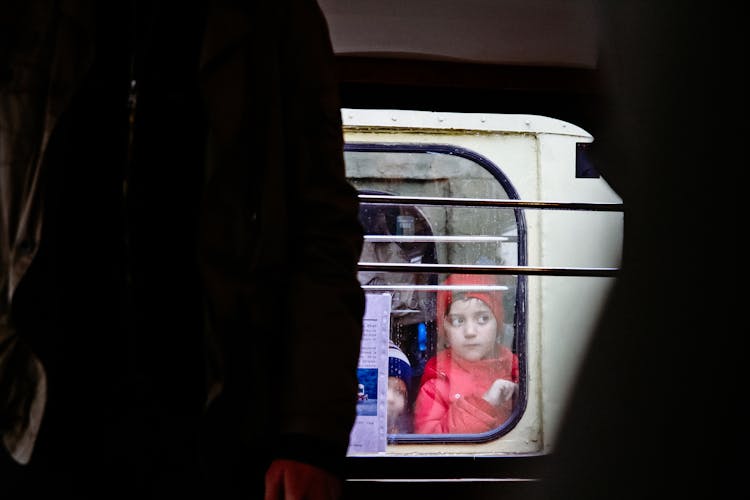 Pensive Kid Standing Near Window In Train