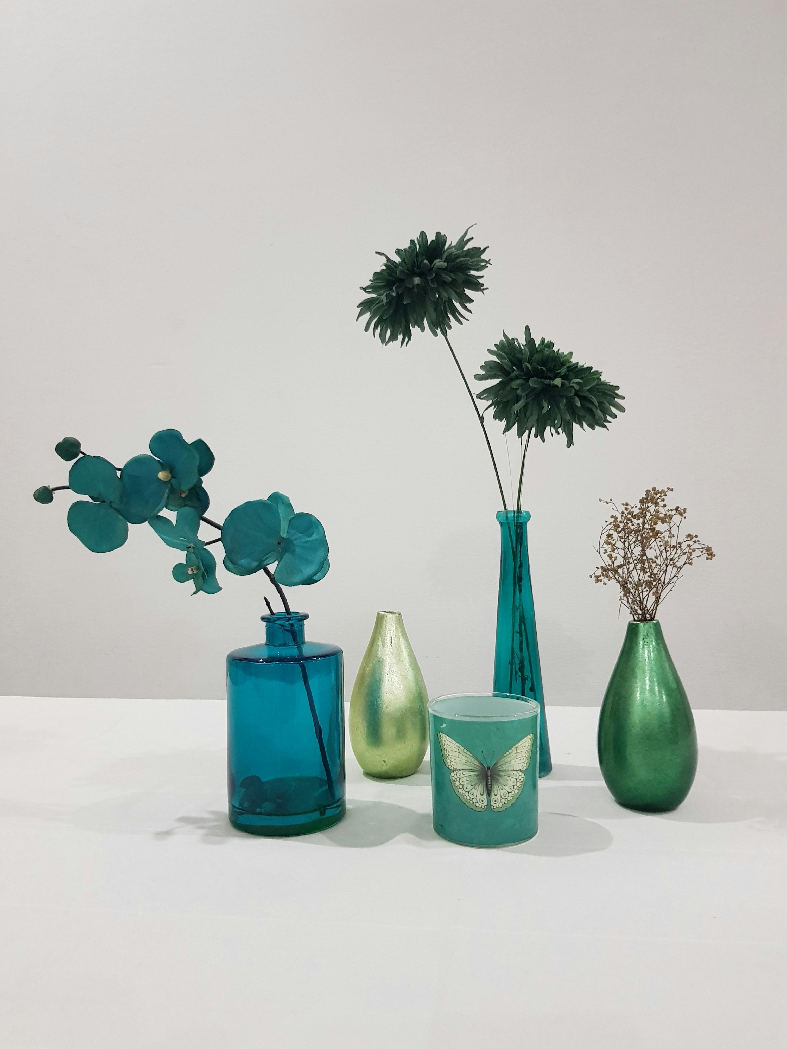 variety of vases and dyed flowers