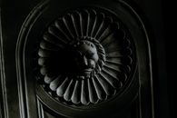Creative plaster moulding in shape on lion head on facade of aged building