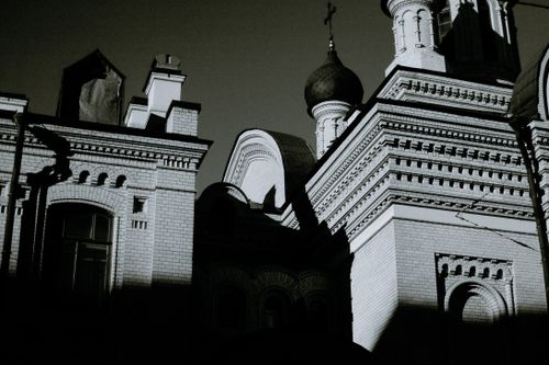 Free From below black and white of aged masonry temple exterior with ornament on walls and cupola in city Stock Photo