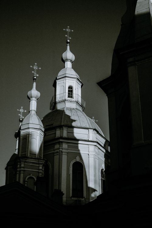 Free Black and white of aged masonry temple exterior with crosses on cupolas under dark sky in city Stock Photo