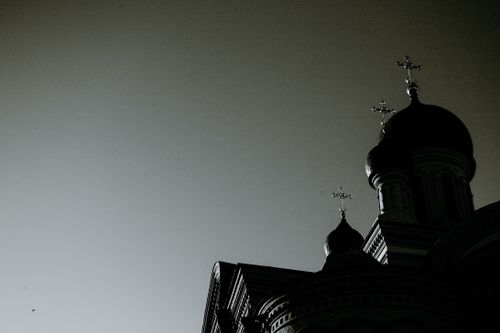 Free Low angle black and white of old stone temple exterior with crosses on domes under gray sky in city Stock Photo