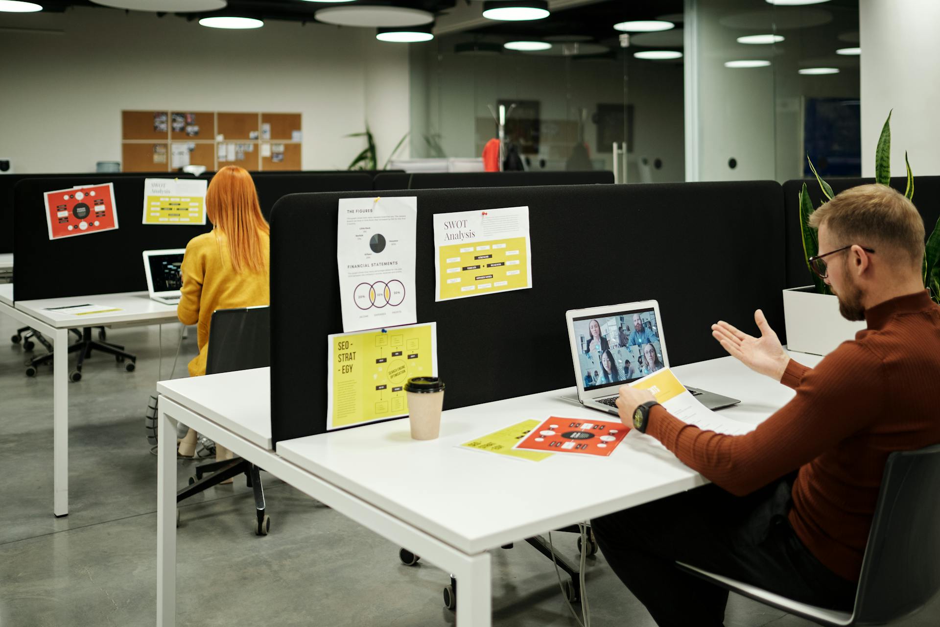 Colleagues working and collaborating virtually at a stylish modern office workspace.