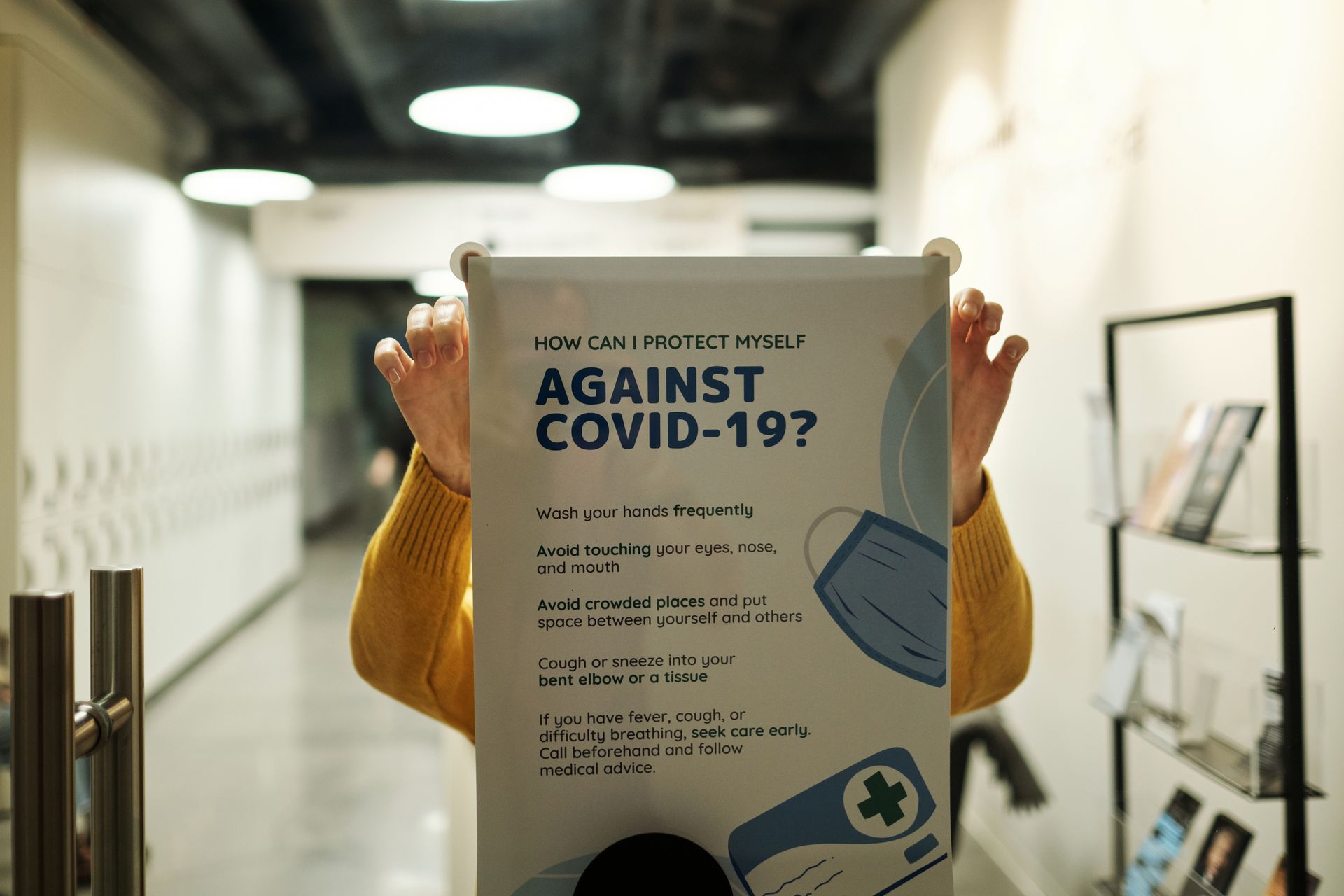 Hanging a Poster About Covid-19 on a Glass Door