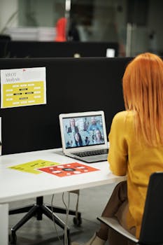 Woman engaged in a video call in an office workspace, highlighting remote work dynamics.