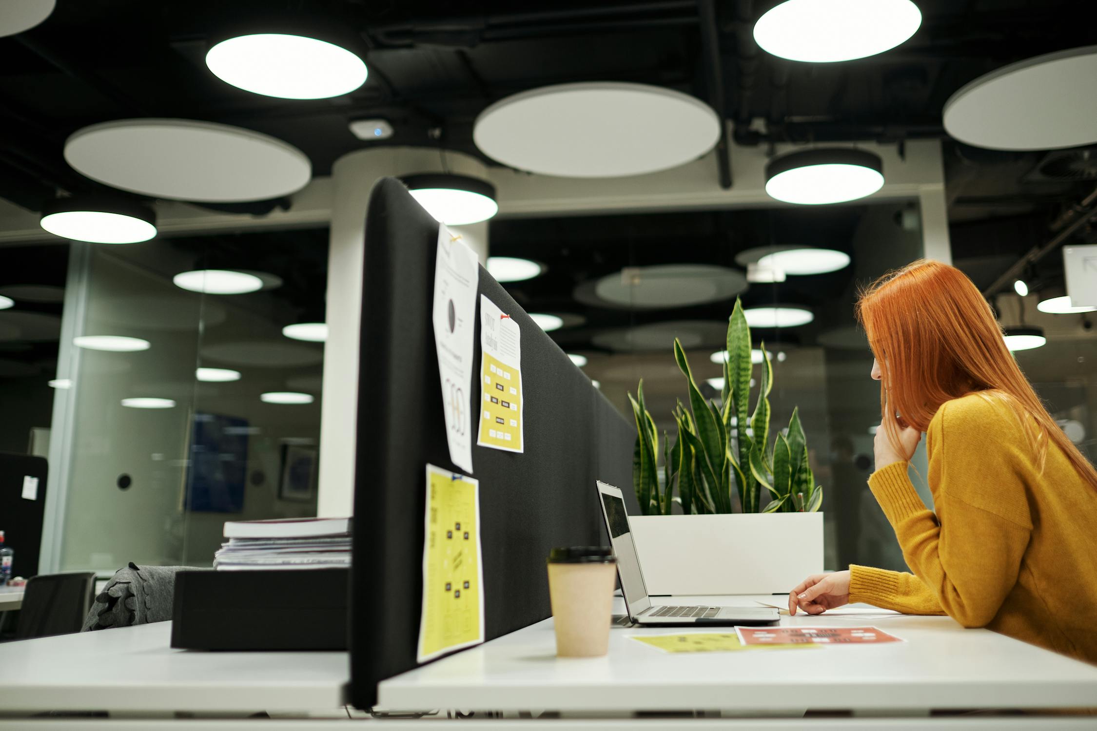 Woman Sitting at Desk in Office with Laptop