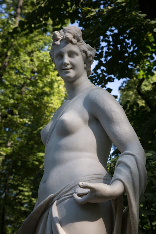 Free Low angle of marble sculpture of Thalia Greek mythology muse against green trees in Summer Garden in Saint Petersburg Stock Photo