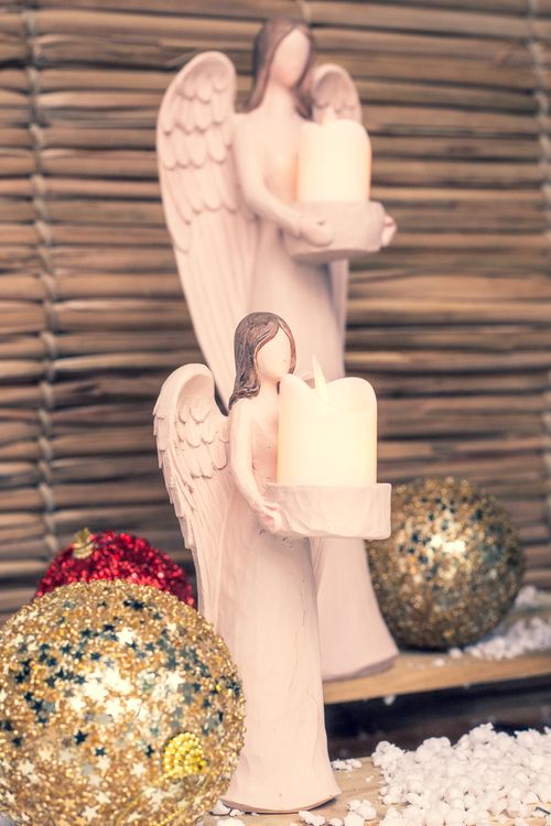 Free Christmas scene with angel figurines holding candles, surrounded by glittering ornaments. Stock Photo
