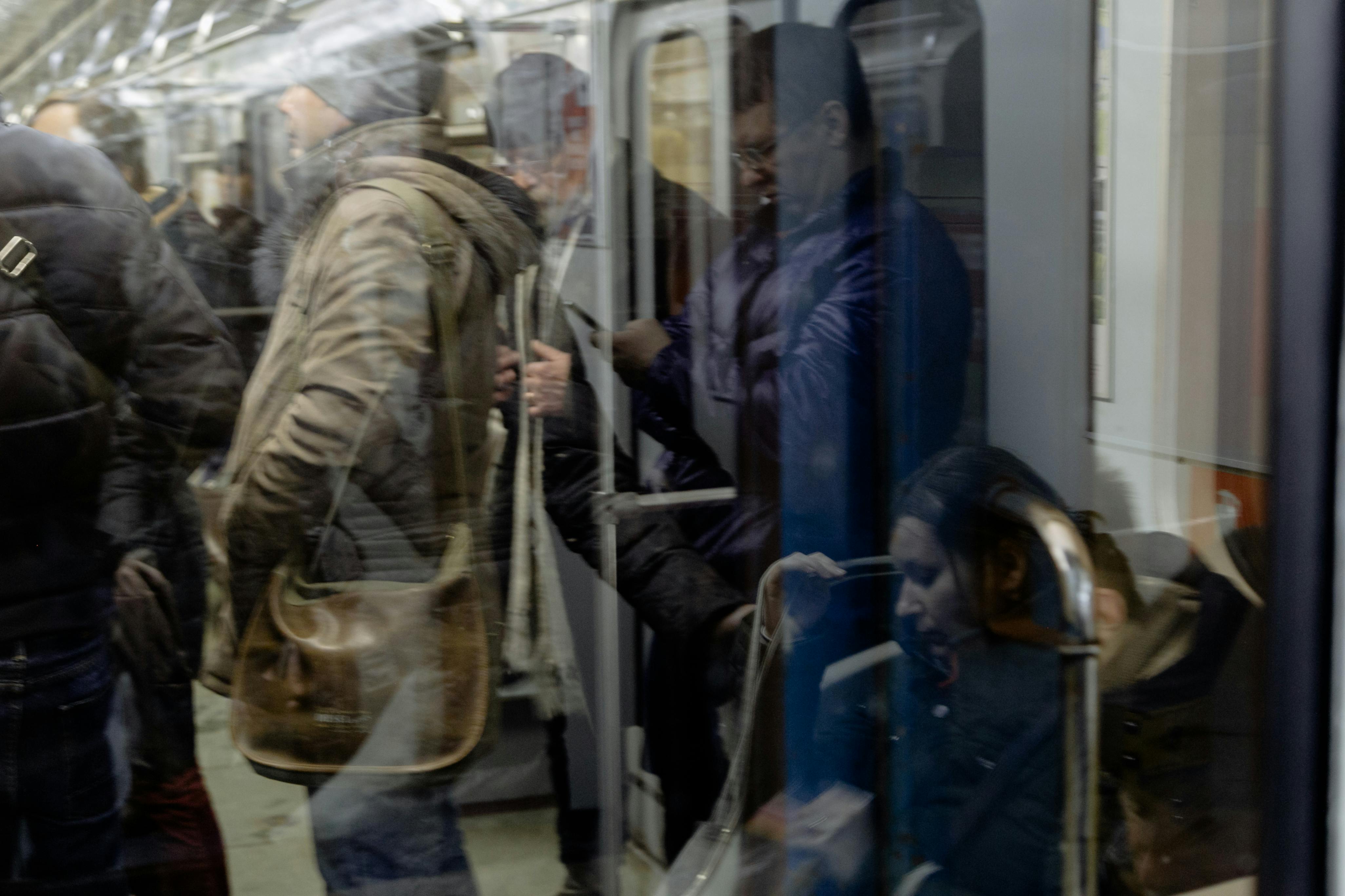 passengers with smartphones travelling on subway train