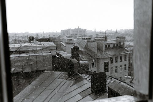 Aged dwelling house facades under white sky in city