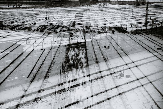 A snowy railway yard captured with a double exposure effect, creating an industrial winter scene.