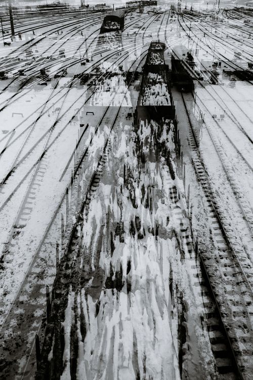 Free Black and white double exposure of industrial metal railway tracks covered with snow located on street in winter day in city Stock Photo