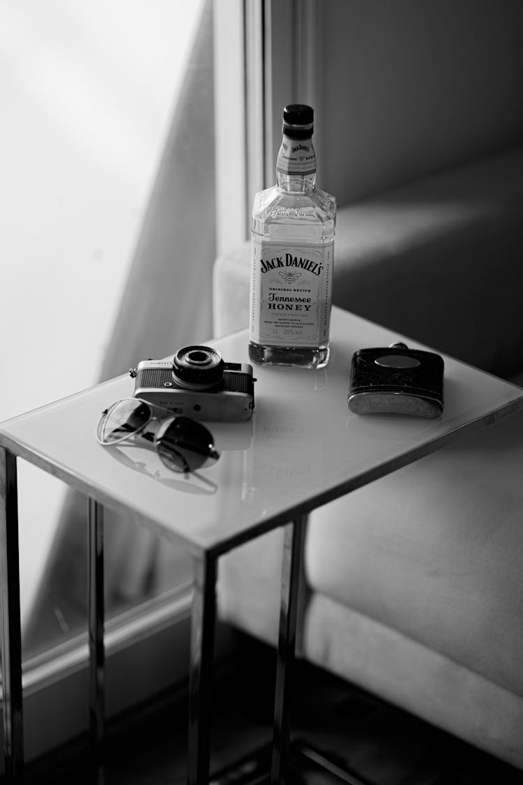 Bottle Of Whiskey On Table With Photo Camera