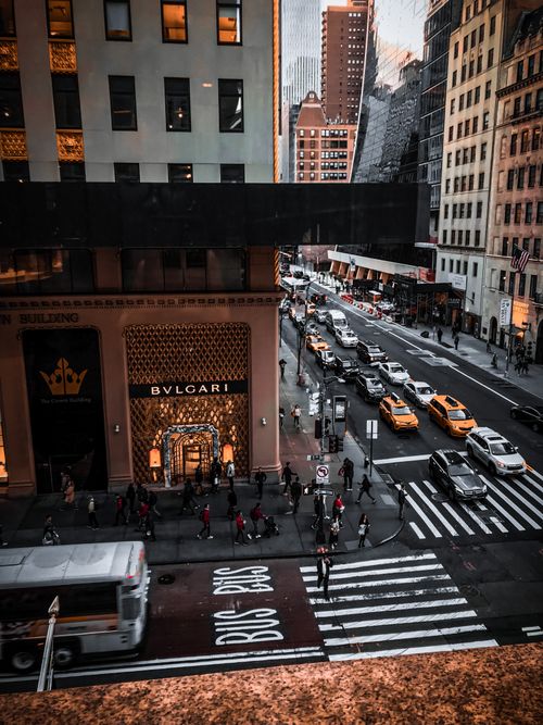 Free A dynamic street view of New York City featuring taxis, pedestrians, and urban architecture. Stock Photo
