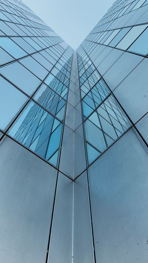 Free Striking low angle shot of a modern skyscraper with glass facade in Amsterdam, Netherlands. Stock Photo